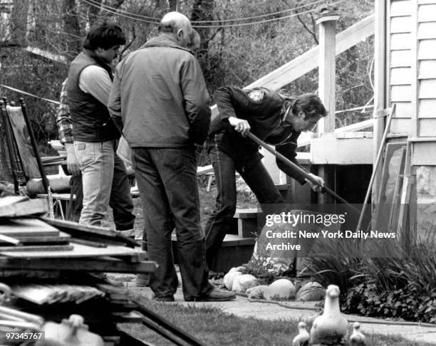 Police search under backstairs for bodies in at 420 Sharrotts Road, Staten Island occupied by Richard Biegenwald.