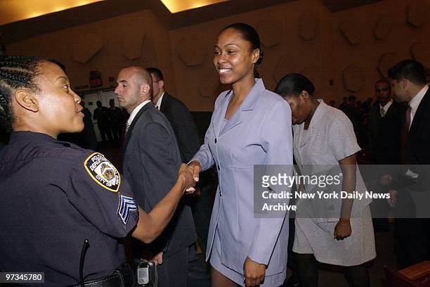 Police Sgt. Lenora Moody congratulates Rosalynn Stewart, one of the new NYPD recruits sworn in at Queens College's Colden Center.