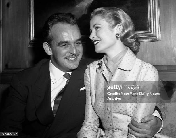 Prince Rainier III of Monaco and Grace Kelly pose for photographers at the Kelly home in Philadelphia after announcing their engagement yesterday.