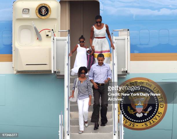 President Barack Obama walk with daughter Malia, followed by First Lady Michelle Obama and daughter Sasha as family leaves Air Force One to board...