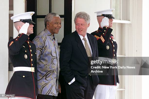 President Bill Clinton and former South African President Nelson Mandela leave the White House after a meeting in the Oval Office.