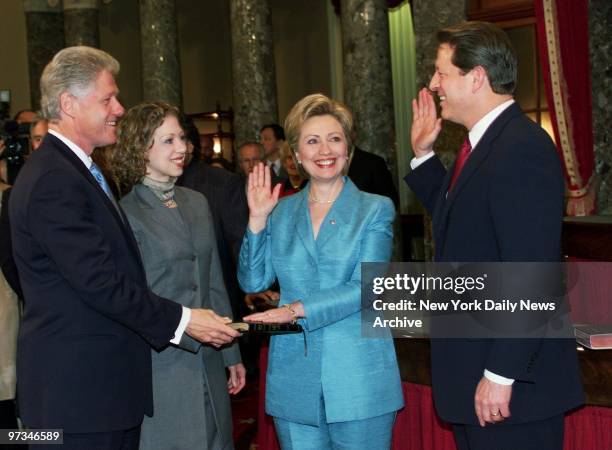 President Bill Clinton holds bible and daughter Chelsea looks on as Hillary Rodham Clinton and Vice President Al Gore go through a re-creation of her...