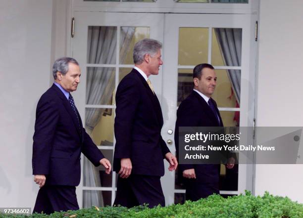 President Bill Clinton is accompanied by Syrian Foreign Minister Farouk al-Sharaa and Israeli Prime Minster Ehud Barak on way to a news conference in...