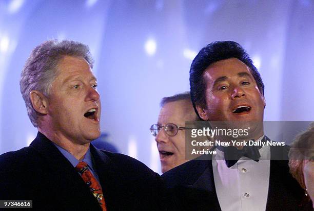 President Bill Clinton joins Wayne Newton in a carol-singing session at the lighting of the National Christmas tree in Washington.