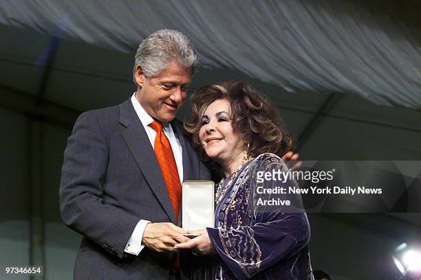President Bill Clinton smiles at actress Elizabeth Taylor as he presents her with the Presidential Citizens Medals at the White House South Lawn...