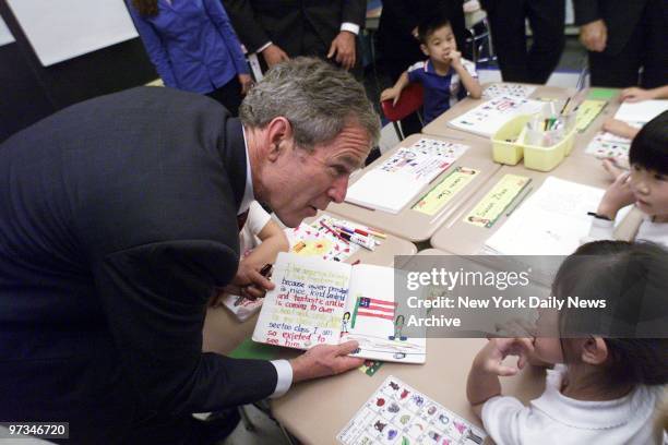 President Bush holds a first-grader's crayon drawing during a visit to Public School 130 on Baxter St. In Chinatown. More than 1,200 children were...