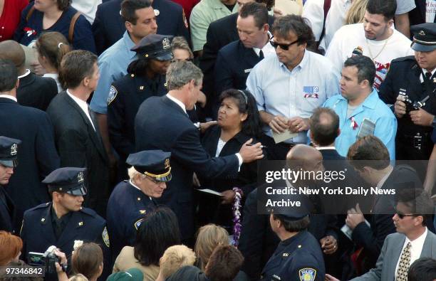 President George W. Bush speaks with relatives of the World Trade Center victims at Ground Zero, where he placed a wreath to mark the first...
