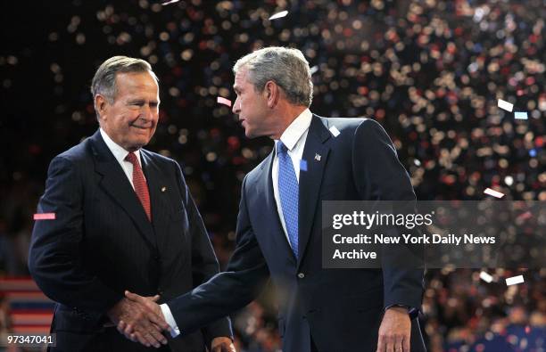 President George W. Bush shakes hands with his father, former President George Bush, after giving his speech on the last night of the Republican...