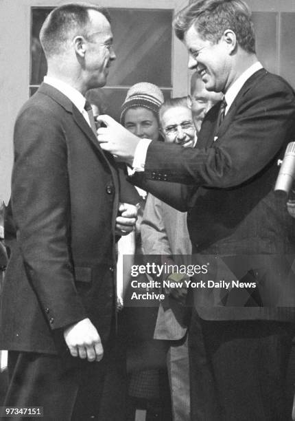 President John F. Kennedy pins medal on Astronaut Alan Shepard.