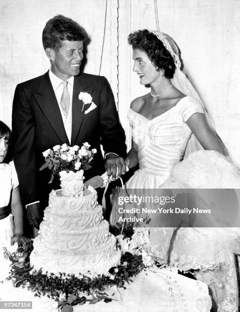 President John F. Kennedy with wife Jacqueline cut the cake at their wedding in Newport, Rhode Island.