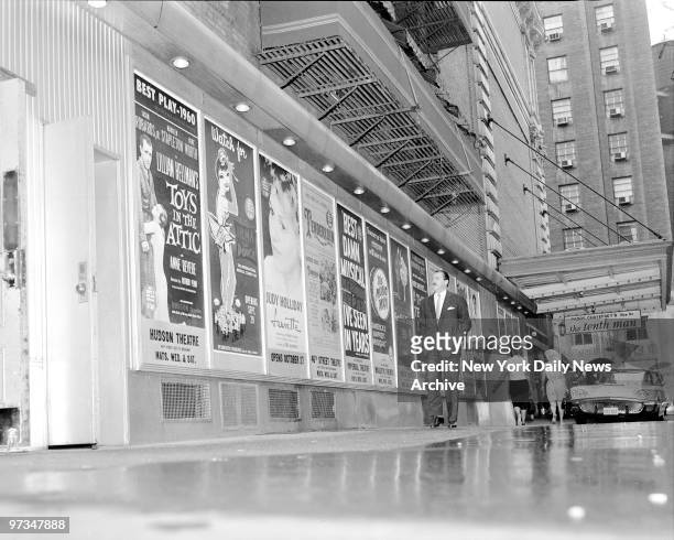 Producer David Merrick, in Shubert Alley, looks over poster plugging one of many shows he'll have on Broadway this season.