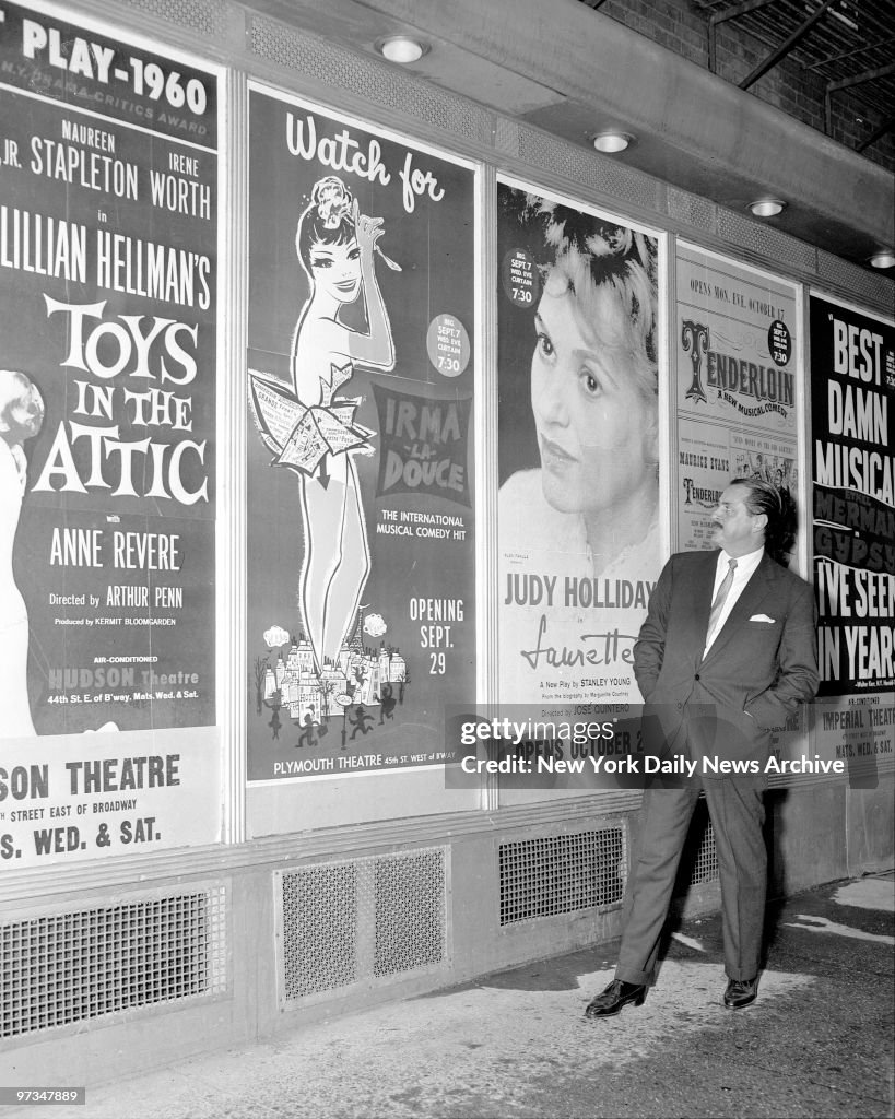 Producer David Merrick, in Shubert Alley, looks over poster 