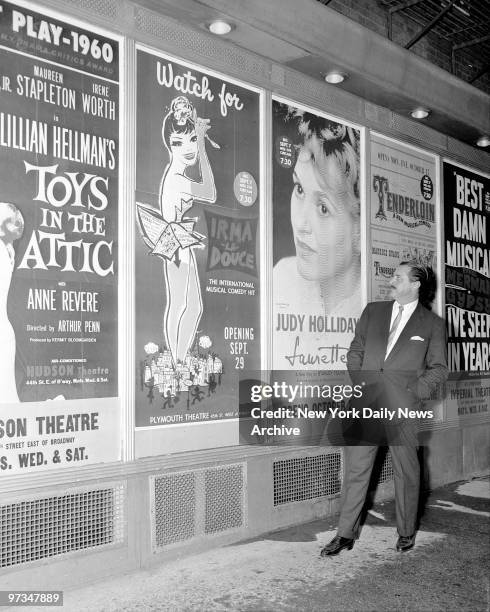 Producer David Merrick, in Shubert Alley, looks over poster plugging one of many shows he'll have on Broadway this season.