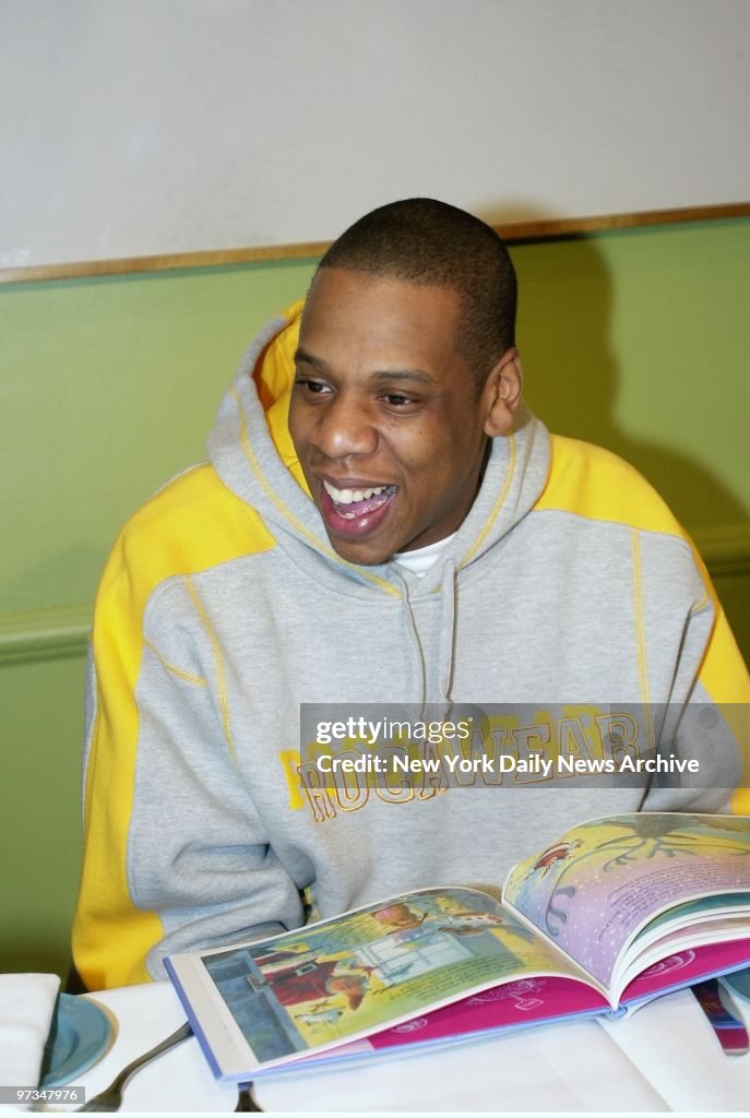 Rapper Jay-Z smiles as he reads a passage from a Christmas book as ...