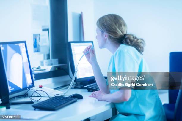 radiologist communicating with patient through microphone, watching computer screens in control room - sigrid gombert stock pictures, royalty-free photos & images