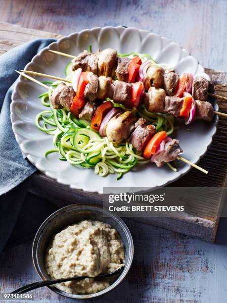 lamb souvlaki skewers, with courgette noodles and baba ganoush, close-up - souvlaki stockfoto's en -beelden