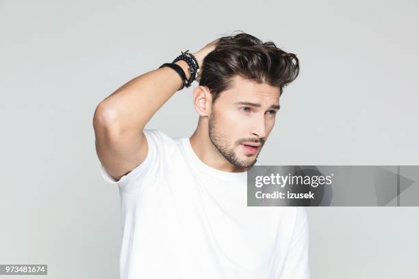 stylish man posing on grey background - pêlo imagens e fotografias de stock