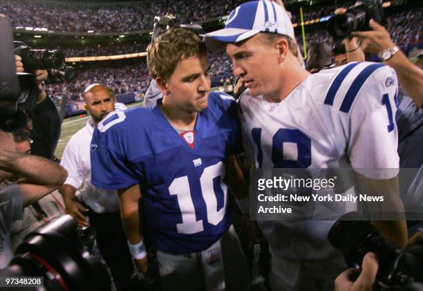 Quarterback brothers, New York Giants' Eli Manning and Indianapolis Colts' Peyton Manning, meet midfield after the Colts' 26-21 win at Giants Stadium.