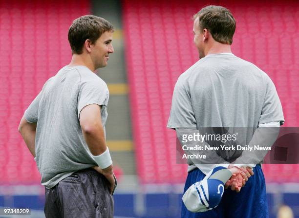 Quarterback brothers, New York Giants' Eli Manning and Indianapolis Colts' Peyton Manning, talk before they meet on the field for a game at Giants...
