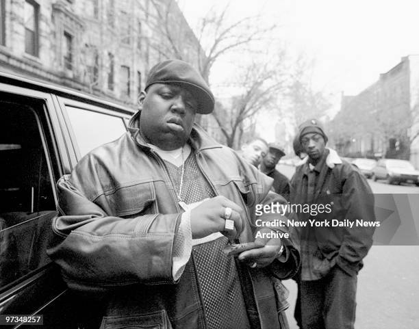 American rapper Notorious B.I.G., aka Biggie Smalls, aka Chris Wallace , rolls a cigar outside his mother's house in Brooklyn, New York, 18th January...