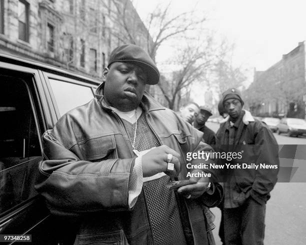 Rapper Notorious B.I.G., aka Biggie Smalls, aka Chris Wallace rolls a cigar outside his mother's house in Brooklyn.