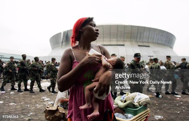 Quintella Williams feeds her 9-day-old baby girl, Akea, outside the Superdome in New Orleans, La., as she awaits evacuation from the flooded city....