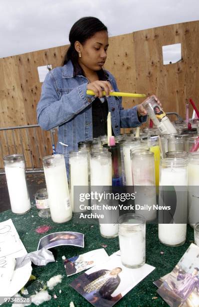 Radayza Montas, lights a candle for her friend, Christina Charlie, killed in the crash of flight 587 on November 12. Members of the "Consuelians," a...