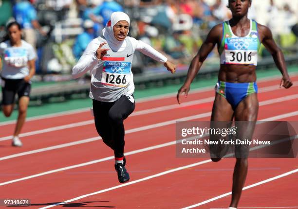 Rakia Al Gassra of Bahrain is pumping hard through the finish in a preliminary heat of the women's 100-meter race at Olympic Stadium during the 2004...