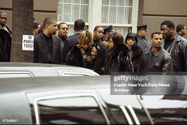 Rapper Lil' Kim is consoled by Mary J. Blige after she breaks down during funeral procession for Notorious B.I.G. .