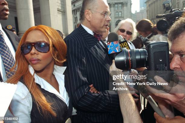 Rapper Lil' Kim leaves Manhattan Federal Court with her lawyer, Mel Sachs, after getting a Nov.18 trial date. Kim was charged with perjury and...