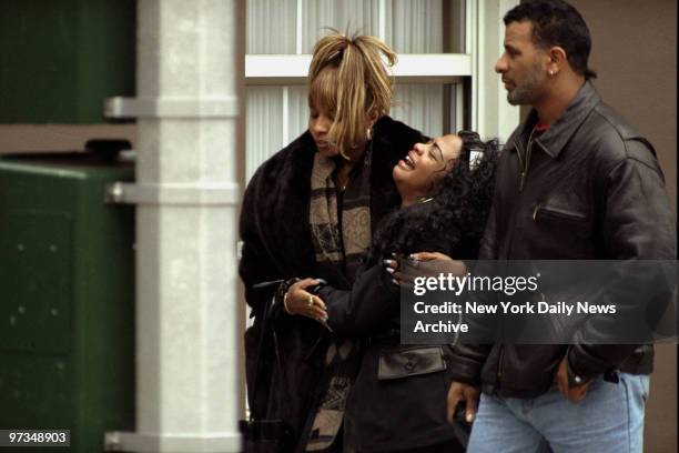 Rapper Lil' Kim of Junior Mafia is consoled by Hip Hop Queen Mary J. Blige following funeral services for Notorious B.I.G. Outside Campbell Funeral...