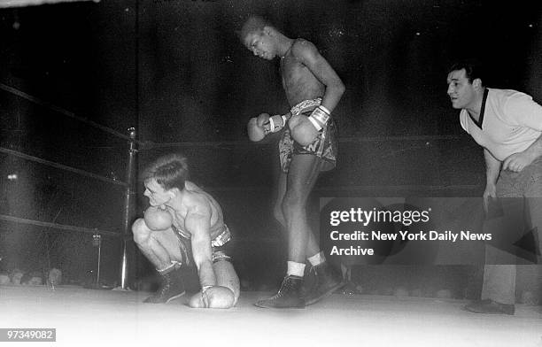 Ray Robinson stands over Jimmy Butler of Atlanta after pounding him to floor in first round of 135-pound final of the Daily News Golden Gloves...