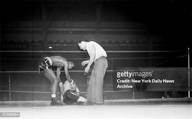Ray Robinson, sensational New York lightweight, helps pick up Joe Vidulich of the Hudson Dispatch team after kayoing him in 46 seconds of the first...