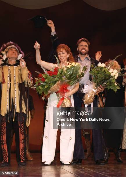 Reba McEntire has an armful of posies as she takes her curtain call after her opening night performance in "Annie Get Your Gun" at the Marquis...
