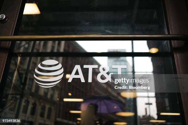 Signage is displayed outside an AT&T Inc. Store in New York, U.S., on Wednesday, June 13, 2018. AT&T Inc.'s sweeping court victory allowing its...
