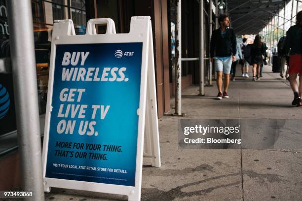 Sign sits outside an AT&T Inc. Store location in New York, U.S., on Wednesday, June 13, 2018. AT&T Inc.'s sweeping court victory allowing its...