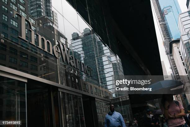 Pedestrians pass in front of the Time Warner Center in New York, U.S., on Wednesday, June 13, 2018. AT&T Inc.'s sweeping court victory allowing its...