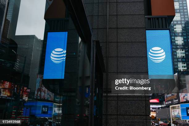 An AT&T Inc. Logo is reflected in a store window in New York, U.S., on Wednesday, June 13, 2018. AT&T Inc.'s sweeping court victory allowing its...