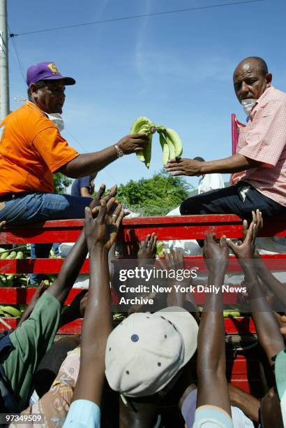 Relief workers hand out bananas at Jimani, Dominican Republic, near the Haitian border, where many residents of other towns devastated by floods came...
