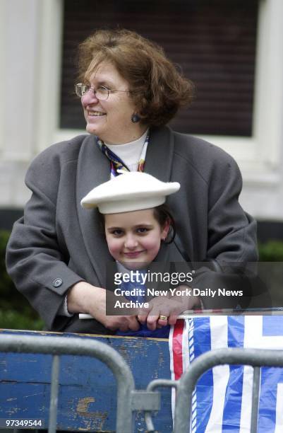 Rena Velitans holds a blue-and-white Greek flag along with the Stars and Stripes, and shields her 8-year-old granddaughter, Katherina Velitans,...