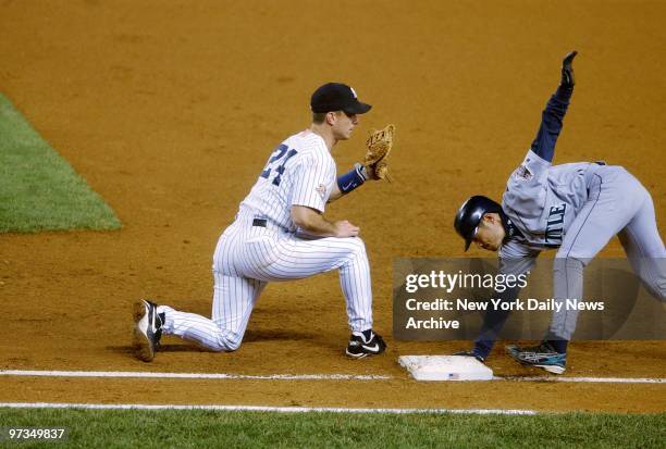 Repeated attempts to hold Seattle Mariners' Ichiro Suzuki at first are unsuccessful as he avoids tag by New York Yankees' Tino Martinez, reaching...