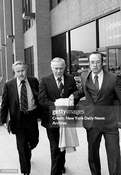 Reputed organized crime figure Aniello Dellacroce is escorted from FBI headquarters in New Rochelle.