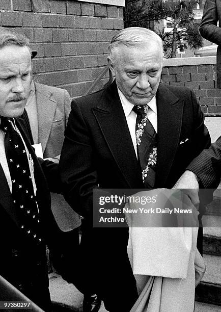 Reputed organized crime figure Aniello Dellacroce is escorted from FBI headquarters in New Rochelle.