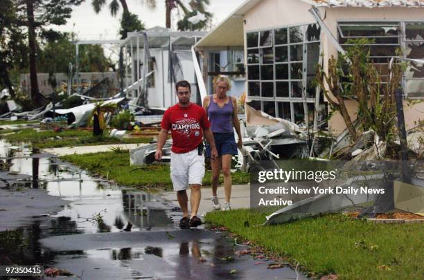 Residents of a trailer park in the oceanfront town of Punta Gorda, Fla., survey the damage as they return to their homes after Hurricane Charley...
