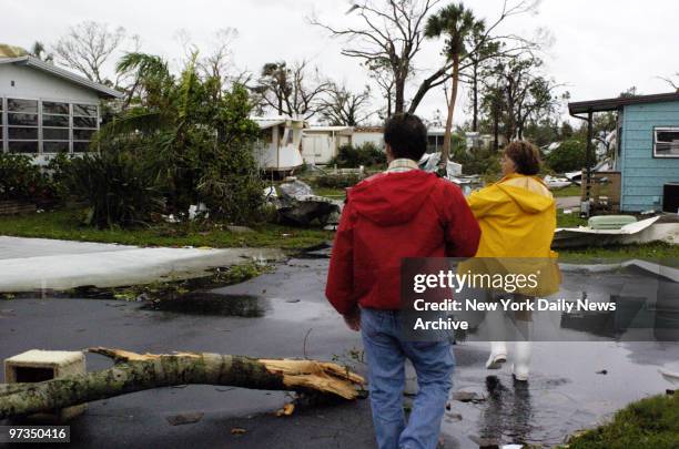 Residents of a trailer park in the oceanfront town of Punta Gorda, Fla., survey the damage as they return to their homes after Hurricane Charley...