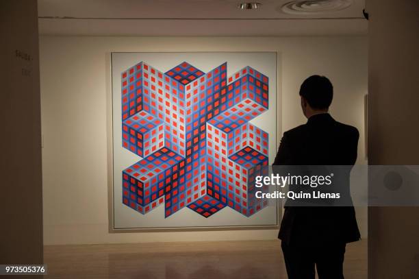 Visitor looks at the painting 'Sinvilag-A' during the press opening of the retrospective exhibition of Victor Vasarely named ‘The Birth of Op Art’....