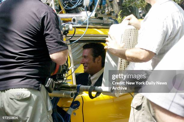 Richard Gere is cooled by a fan as he sits in a taxi during filming of the movie "The Hoax" in Washington Square Park. Gere plays the part of author...