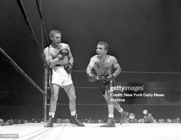 Right eye closed, Tiberio Mitri is pounded into the ropes in a late round by Jake LaMotta.