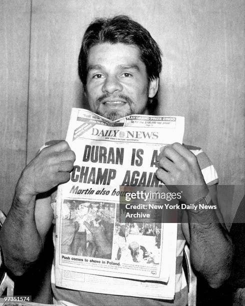 Roberto Duran shows Daily News front page headline announcing he has regained his boxing title.