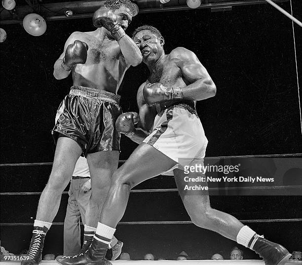 Rocky Marciano puffs' Ezzard Charles' cheeks with savage left in the 13th round.